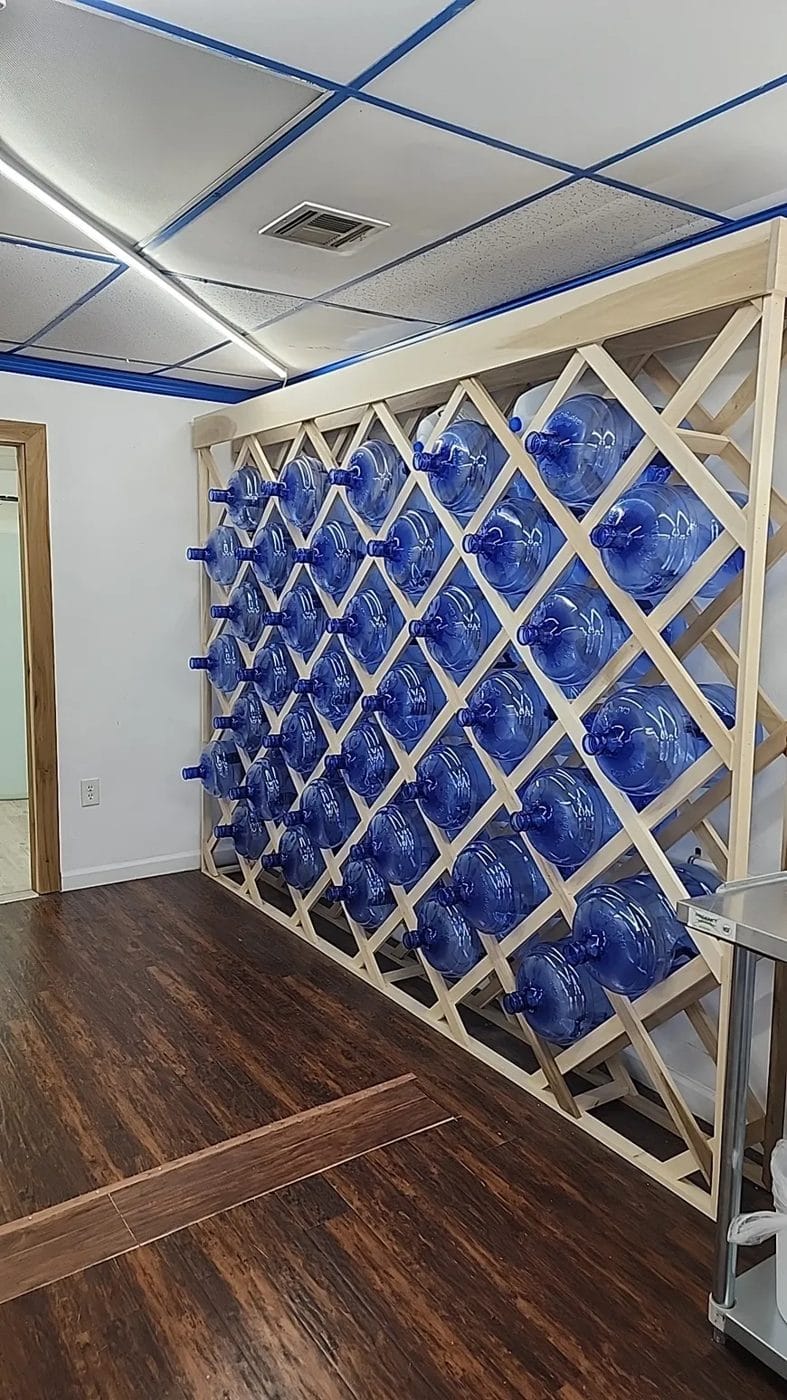 Wall rack stocked with 5-gallon water bottles at H2O to Go